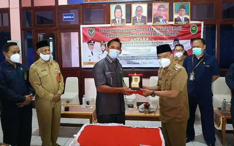Bupati Seruyan Yulhaidir saat menyerahkan plakat kepada Ketua Pengadilan Negeri Sampit