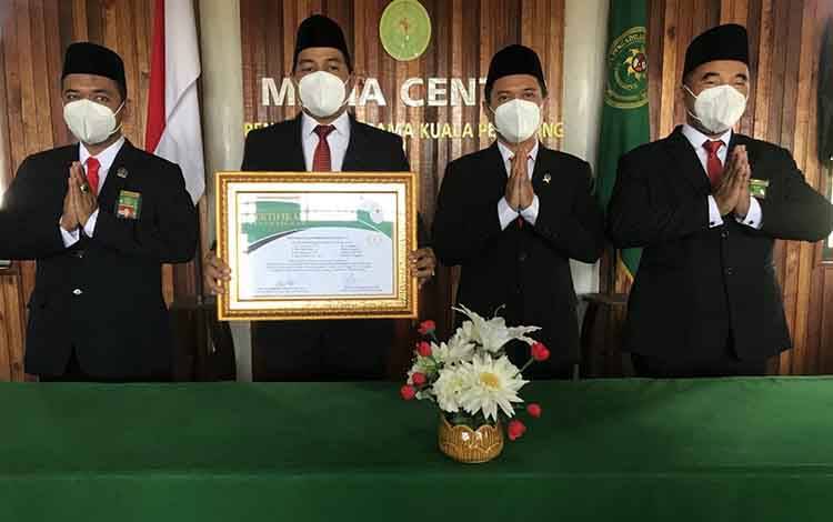 Ketua Pengadilan Agama Kuala Pembuang, Roni Fahmi menunjukkan piagam penghargaan.