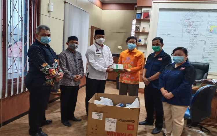 Bupati Sukamara, Windu Subagio menerima hibah thermo gun dari Ketua  KPU Sukamara, Ahmad Zen Alantany