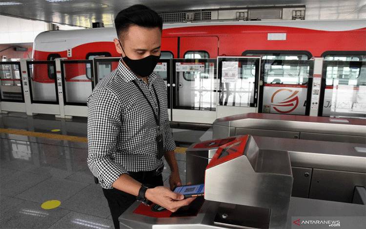 Penumpang memindai kode batang tiket dari gawainya di gerbang tiket nirsentuh LRT Jakarta di Stasiun LRT Velodrome, Jakarta, Rabu (5/8/2020). ANTARA FOTO/Indrianto Eko Suwarso/foc.