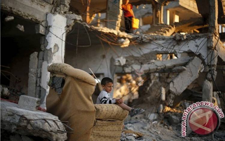 Seorang bocah Palestina duduk di sofa di depan rumahnya yang menurut saksi hancur akibat perang 50 hari musim panas lalu di Kota Gaza, Senin (4/5). Israel melakukan "kejahatan besar dan belum pernah terjadi" terhadap warga sipil Palestina saat terjadi perang Gaza 2014.(REUTERS/Mohammed Salem )