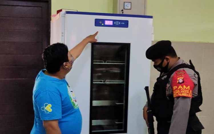 Anggota Sabhara Polresta Palangka Raya bersama petugas Dinas Kesehatan melaksanakan pengecekan suhu lemari pendingin penyimpanan vaksin covid-19