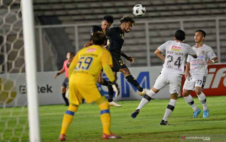 Pesepak bola Tim Nasional (Timnas) U-23 Yakob Sayuri (tengah) menyundul bola ke arah gawang klub Bali United dalam pertandingan uji coba di Stadion Madya, Gelora Bung Karno (GBK), Jakarta, Minggu (7/3/2021)