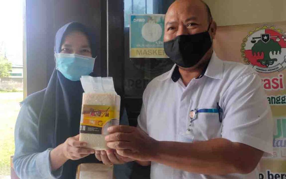 Perwakilan Bulog Sampit saat menyerahkan beras bervitamin kepada salah seorang warga.