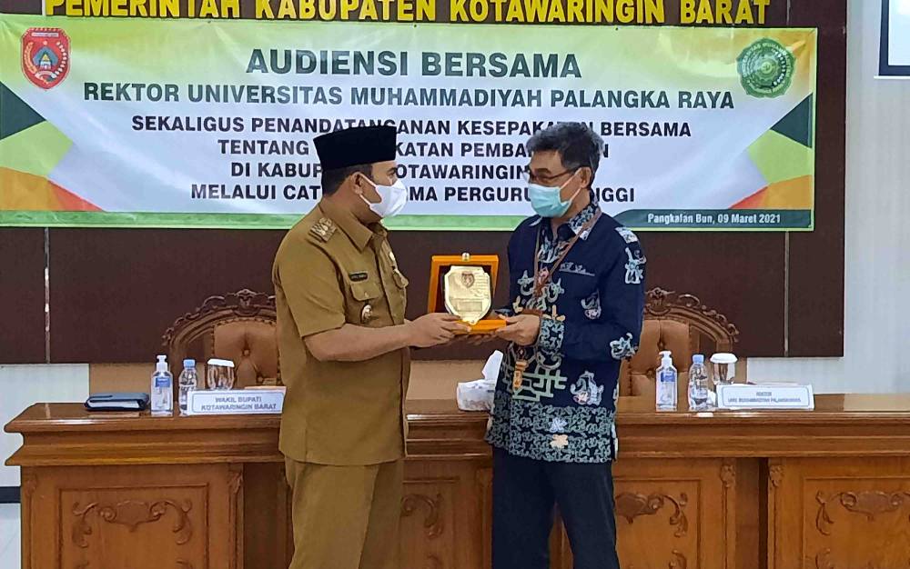 Wabup Kobar Ahmadi Riansyah serahkan plakat kepada Rektor UMP Sonedi, dalam acara MoU Catur Dharma Perguruan Tinggi.