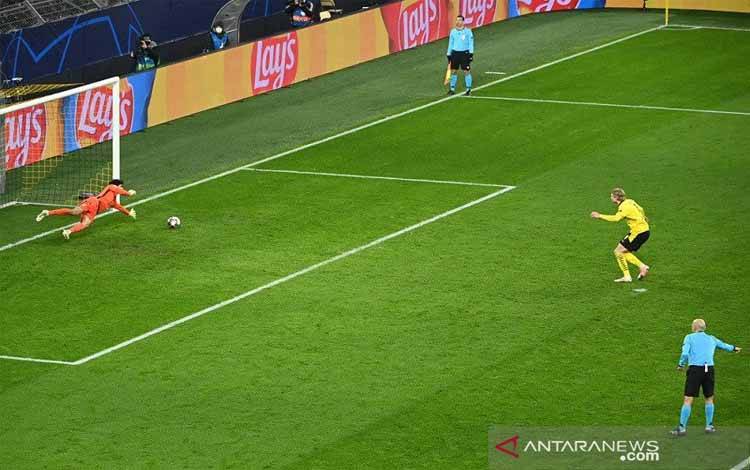 Penyerang Borussia Dortmund Erling Haaland (tengah) mengeksekusi penalti untuk mencetak gol kedua ke gawang Sevilla dalam leg kedua 16 besar Liga Champions di Stadion Signal Iduna Park, Dortmund, Jerman, Selasa (9/3/2021) waktu setempat