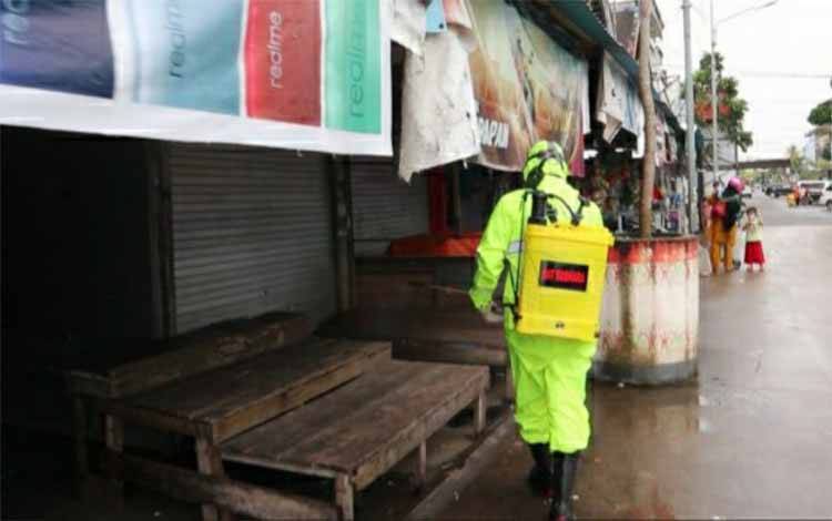 Personel Satsabhara Polres Kapuas melakukan penyemprotan cairan disinfektan di kawasan pasar