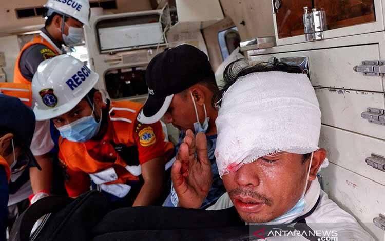 Seorang pria terluka duduk di dalam sebuah ambulans setelah polisi menembakkan peluru karet saat protes terhadap kup militer di Mandalay, Myanmar, Sabtu (20/2/2021)