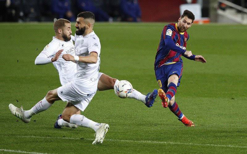 Megabintang Barcelona Lionel Messi (kanan) melepaskan tembakan untuk mencetak gol keempat timnya ke gawang Huesca dalam lanjutan Liga Spanyol di Stadion Camp Nou, Barcelona, Spanyol, Senin (15/3/2021) waktu setempat. (foto : ANTARA/REUTERS/Albert Gea)