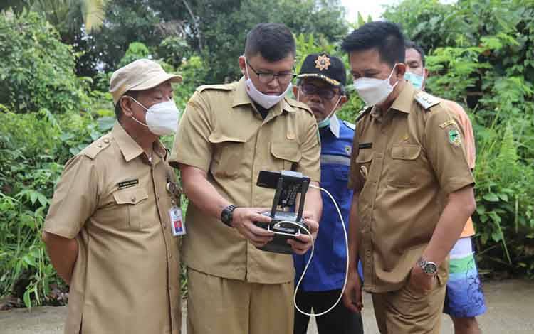 Bupati Barito Utara, Nadalsyah meninjau lokasi di Jalan Pendreh yang terkena banjir luapan Sungai Bengaris menggunakan drone