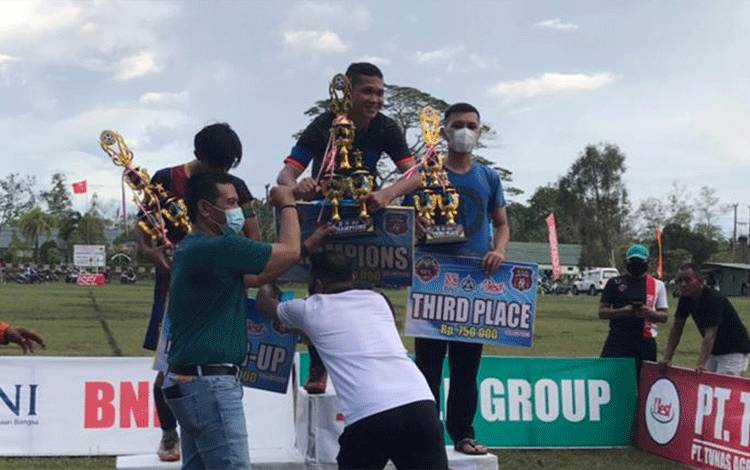Ketua KONI Kotim Ahyar Umar saat menyerahkan trofi kepada pemenang turnamen sepakbola.