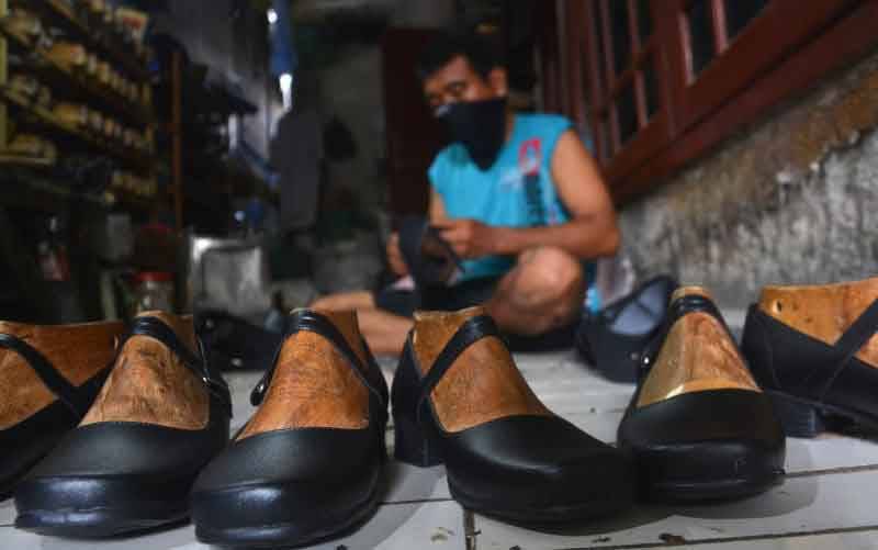 Seorang pekerja menyelesaikan pembuatan sepatu di industri rumahan Surodinawan, Prajuritkulon, Kota Mojokerto, Jawa Timur. (foto : ANTARA FOTO/Syaiful Arif/pras)
