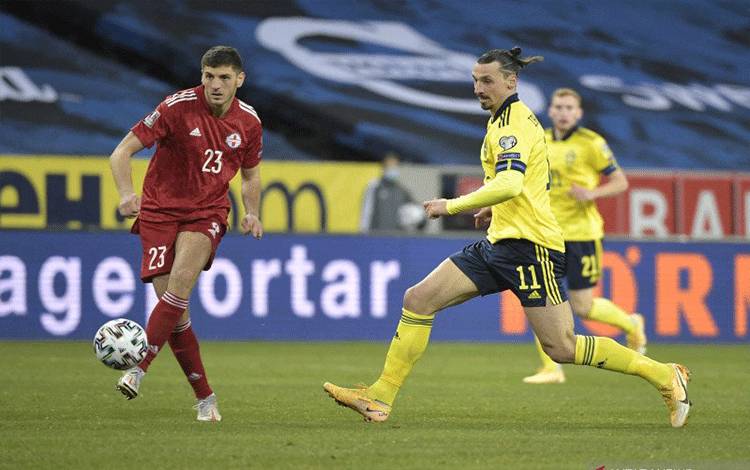 Penyerang Swedia, Zlatan Ibrahimovic dan bek Georgia, Lasha Dvali bersaing memperebutkan bola dalam pertandingan kualifikasi Piala Dunia 2022 di Solna, Swedia pada 26 Maret 2021. (AFP/PONTUS LUNDAHL)