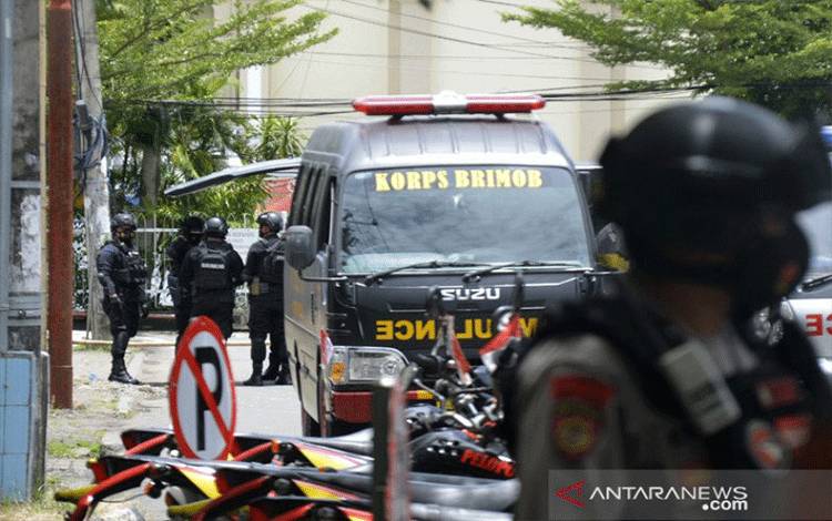 Petugas kepolisian berjaga di lokasi dugaan bom bunuh diri di depan Gereja Katolik Katedral, Makassar, Sulawesi Selatan, Minggu (28/3/2021). ANTARA FOTO/Abriawan Abhe/foc.