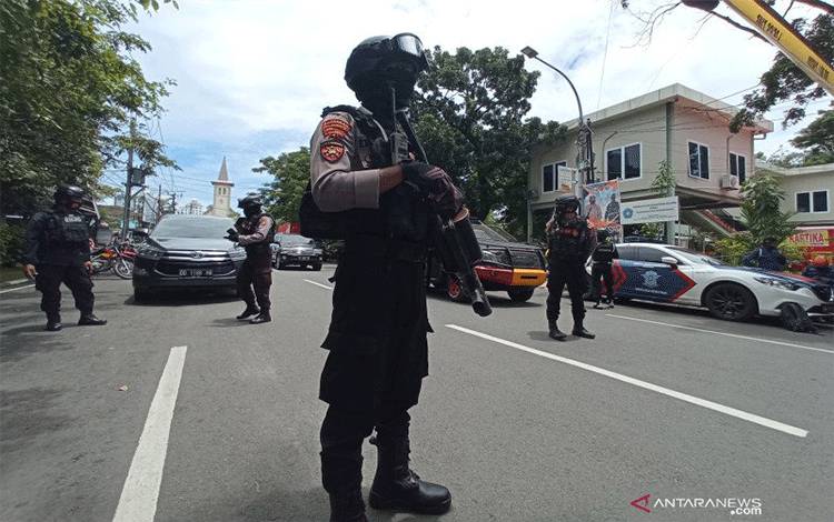 Petugas kepolisian berjaga di lokasi ledakan bom di depan Gereja Katedral Makassar, Sulawesi Selatan, Minggu (28/3/2021). (ANTARA FOTO/Abrian Abhe/foc)