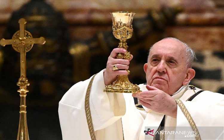 Paus Fransiskus merayakan misa Malam Natal dengan kehadiran hanya beberapa anggota umat, karena peraturan pembatasan terkait COVID-19, di Basilika Santo Petrus di Vatikan, (24/12/2020)