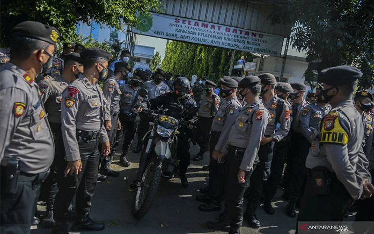 Petugas Kepolisian melakukan pengamanan saat berlangsungnya sidang lanjutan kasus pelanggaran protokol kesehatan dengan terdakwa Rizieq Shihab di kawasan Pengadilan Negeri (PN) Jakarta Timur, Jakarta, Jumat (26/3/2021). ANTARA FOTO/Galih Pradipta/foc.