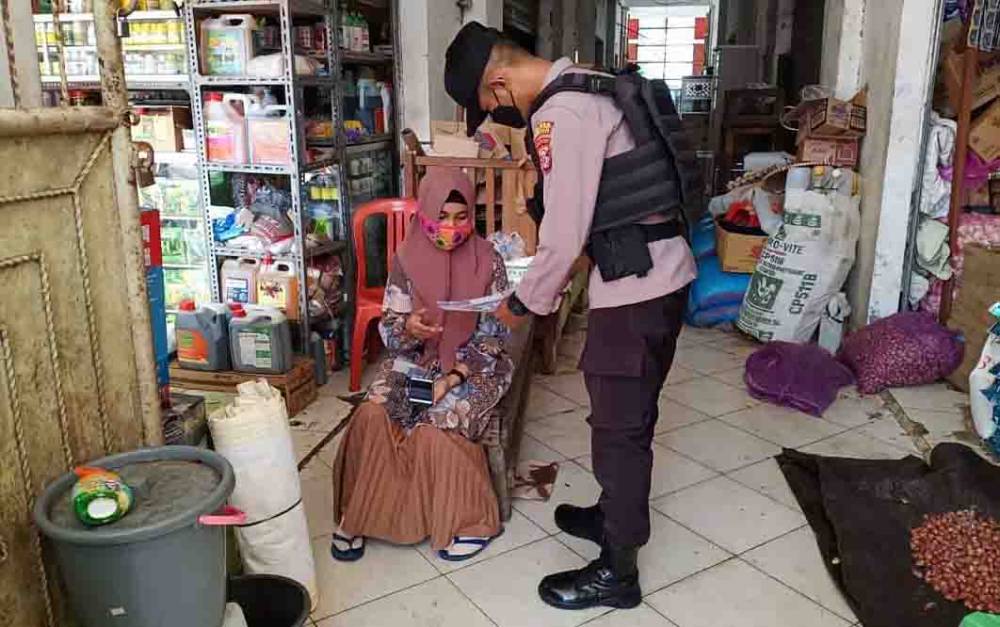 Personel Polres Seruyan saat memberikan informasi penerimaan Polri kepada salah satu warga di Pasar Kuala Pembuang.