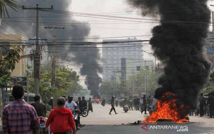 Ban terbakar di sebuah jalan saat protes terhadap kup militer terus berlanjut, di Mandalay, Myanmar, Sabtu (27/3/2021)