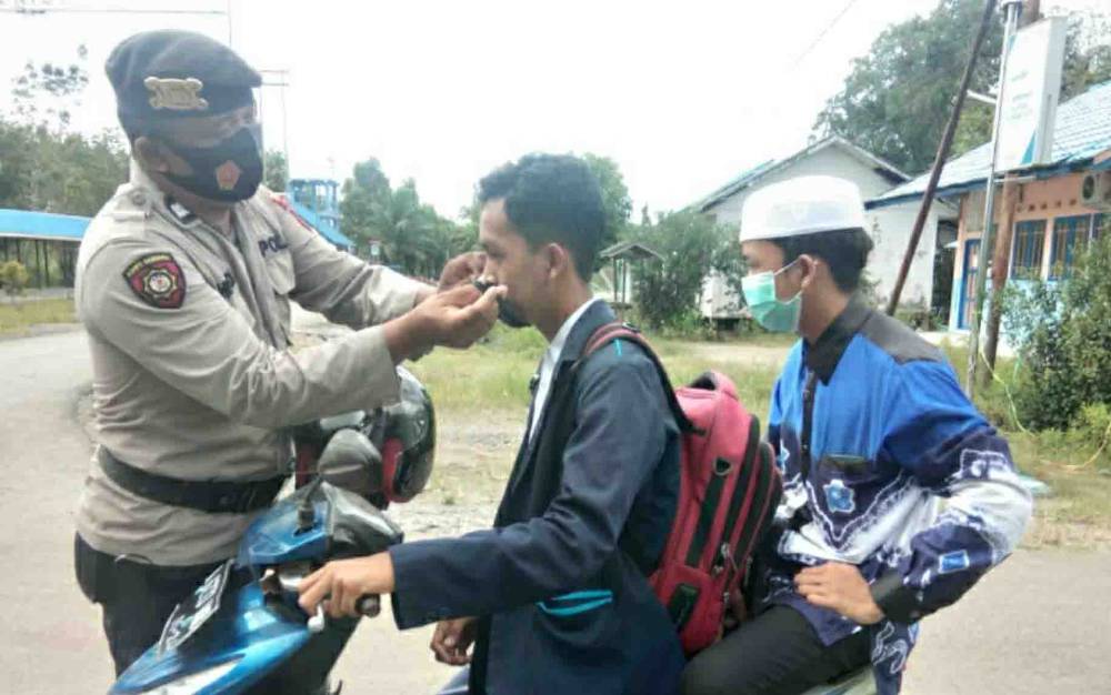 Personel Polsek Basarang saat membagikan masker kepada warga pada Kamis, 1 April 2021.