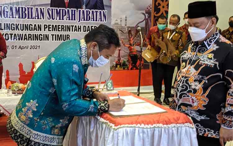 Plt Camat Mentaya Hikir Utara, Muslih saat menandatangani serah terima jabatan yang disaksikan Bupati Kotim, Halikinnor.