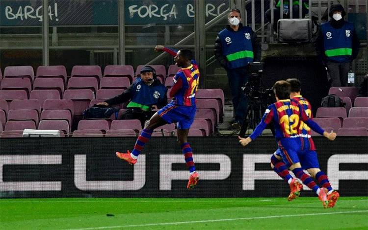Striker Barcelona Ousmane Dembele (kiri) merayakan golnya yang mengantarkan Barca menang melawan Real Valladolid FC di Stadion Camp Nou, Barcelona, 5 April 2021. (AFP/PAU BARRENA)