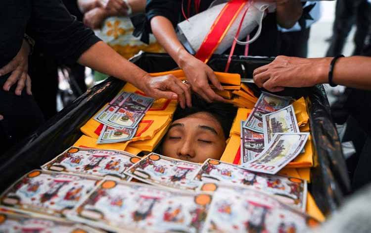 Warga meletakkan kertas Joss pada peti mati, saat menghadiri pemakaman Khan Nyar Hein, mahasiswa kedokteran berusia 17 tahun yang tewas tertembak aparat keamanan yang melakukan tindakan keras pada unjuk rasa anti-kudeta di Yangon, Myanmar, Selasa (16/3/2021)