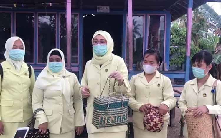 Ketua IAD Karini Seruyan, Yulia Romy Rozali, memperlihatkan salah satu kerajinan tas berbahan purunyang menjadi kreasi pengrajin di Desa Pematang Panjang