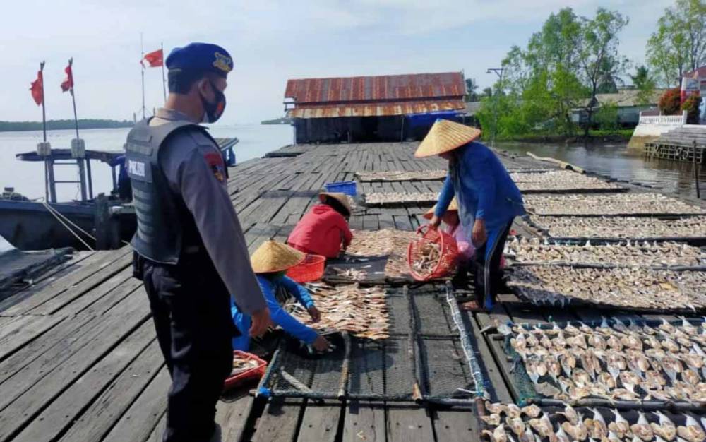 Polisi saat memberikan imbauan kepada perajin ikan kering di Desa Sungai Undang, Seruyan.
