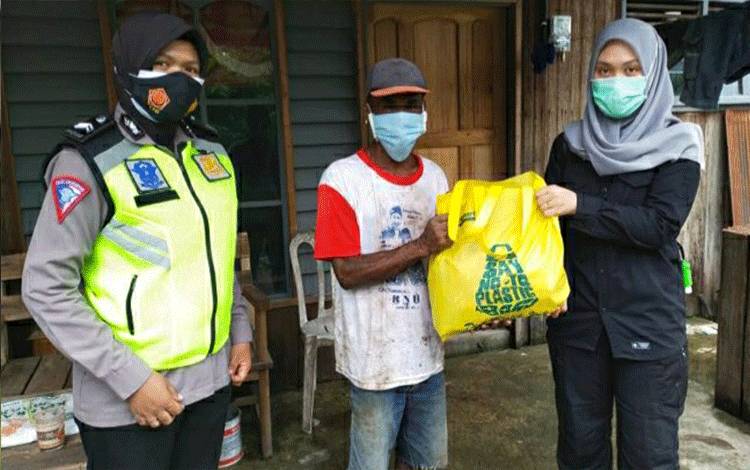 Personel Polwan Polres Kapuas saat menyerahkan bantuan sembako kepada warga di Kecamatan Selat.