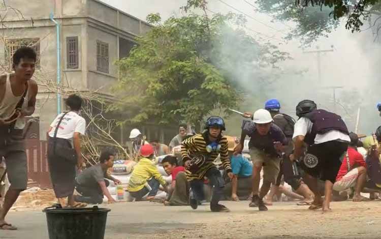 Pengunjuk rasa berlindung saat bentrok dengan pasukan keamanan di Monywa, Myanmar, Minggu (21/3/2021), dalam gambar dari sebuah video yang didapatkan oleh Reuters