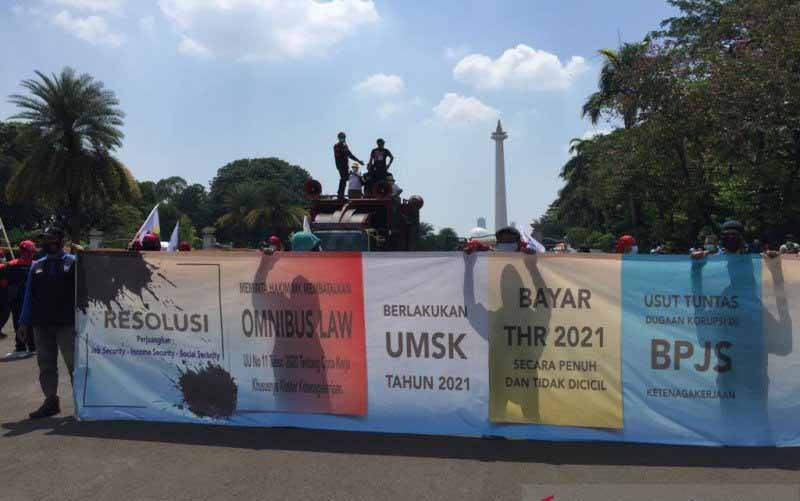 Buruh melakukan unjuk rasa dan menuntut dibatalkannya Undang-Undang (UU) Nomor 11 Tahun 2020 tentang Cipta Kerja di Pintu Monas Gambir, Jakarta Pusat, Rabu (21/04/2021). (foto : ANTARA/Mentari Dwi Gayati)