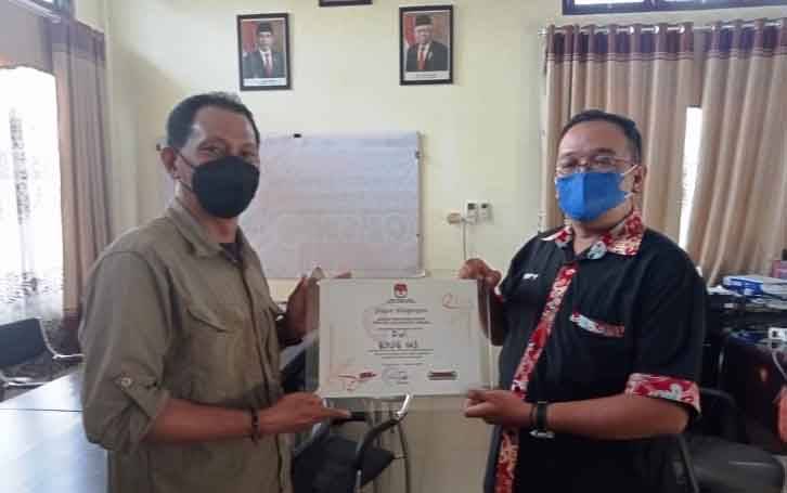 Ketua KPU Kabupaten Gumas Stepenson (kiri) menyerahkan piagam penghargaan kepada Ketua PWI Kabupaten Gumas Popy, Oktovery.