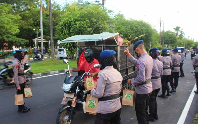 Personel Satbrimob Polda Kalteng saat membagikan takjil di Bundaran Besar Kota Palangka Raya