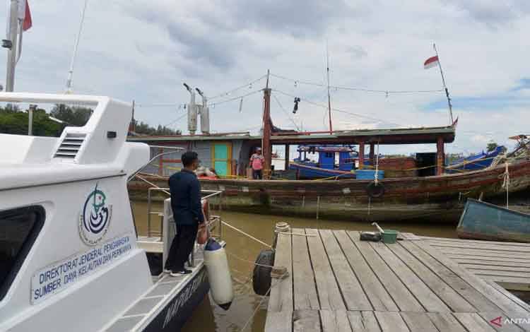 Petugas Pangkalan Pengawasan Sumber Daya Kelautan dan Perikanan (PSDKP) mengamankan satu unit kapal ikan pukat trawl (kanan) pascapenangkapan di dermaga Lampulo, Banda Aceh, Aceh, Kamis (28/1/2021)