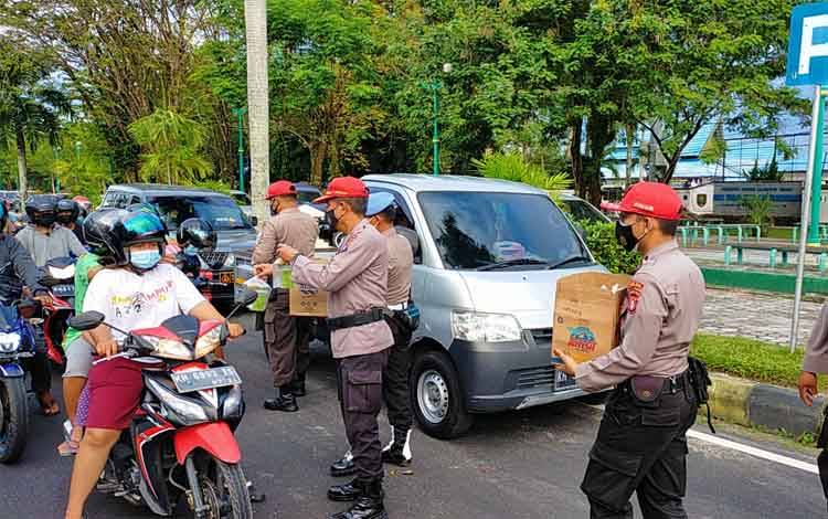 Anggota SPN Polda Kalteng saat membagikan takjil di Jalan Yos Sudarso depan Pos Polisi Bundaran Besar Palangka Raya