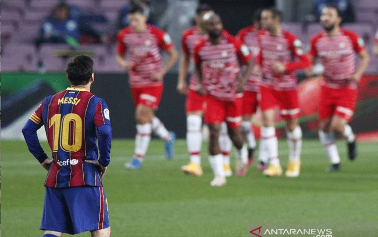 Reaksi Lionel Messi (kiri) setelah Barcelona kemasukan gol kedua Granada dalam pertandingan Liga Spanyol di Camp Nou, Barcelona, Spanyol pada 30 April 2021.(REUTERS/ALBERT GEA)
