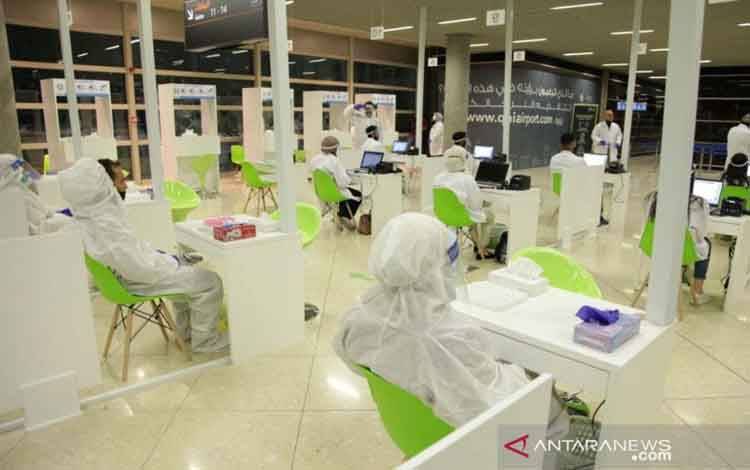 Tenaga kesehatan menunggu penumpang untuk diperiksa di Bandara Internasional Queen Alia setelah penerbangan internasional reguler dibuka kembali --setelah ditutup akibat penyebaran penyakit virus corona (COVID-19), di Amman, Yordania, Selasa (8/9/2020)
