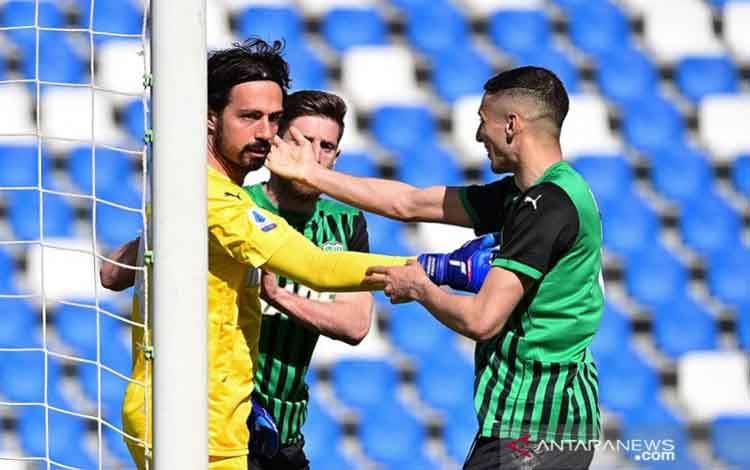 Kiper Sassuolo Andrea Consigli (kiri) diselamati rekan-rekannya seusai sukses mementahkan eksekusi penalti penyerang Atalanta Luis Muriel dalam lanjutan Liga Italia di Stadion Mapei, Reggio Emilia, Italia, Minggu (2/5/2021)