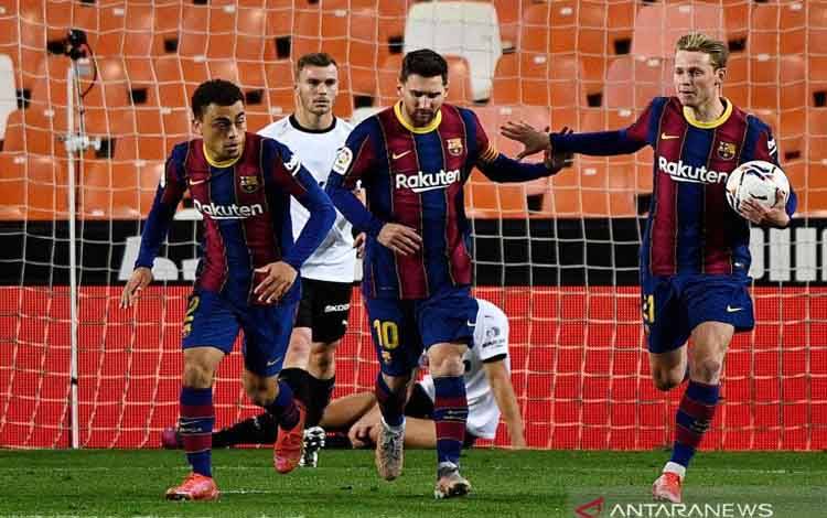 Megabintang Barcelona Lionel Messi (kedua kanan) melakukan selebrasi bersama Antoine Griezmann (kanan) dan Sergino Dest (kiri) seusai mencetak gol pertamanya ke gawang Valencia dalam lanjutan Liga Spanyol di Stadion Mestalla, Valencia, Spanyol, Minggu (2/5/2021) waktu setempat