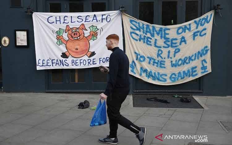 Seorang suporter Chelsea melintas di hadapan spanduk protes terkait Liga Super Eropa yang disematkan di luar Stadion Stamford Bridge jelang sepak mula laga Liga Inggris melawan Brighton & Hove Albion pada 20 April 2021