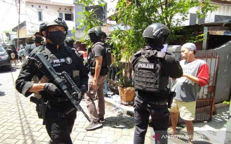 Dokumentasi polisi bersenjata lengkap mengamankan area saat pengeledahan rumah pelaku bom bunuh diri Gereja Katedral, Jalan Tinumbu, Kota Makassar, Sulawesi Selatan