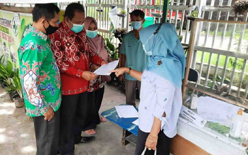 Plt Kasi Penyelenggaraan Haji dan Umrah Kemenag Kapuas, M. Poteran Sosilo saat memantau vaksinasi CJH reguler.