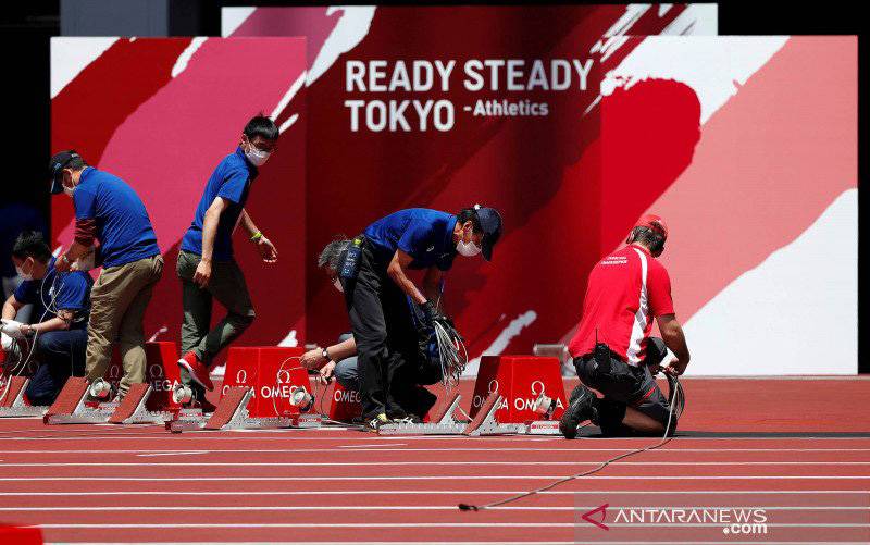 Sejumlah ofisial menyiapkan perlengkapan dalam uji coba pelaksanaan pertandingan atletik untuk Olimpiade Tokyo di Olympic Stadium, Tokyo, Jepang, Minggu (9/5/2021). (foto : ANTARA FOTO/REUTERS/Issei Kato/foc)