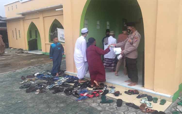 Personel Polres Seruyan saat membagikan masker kepada jamaah salat Idul Fitri disalah satu masjid di Kuala Pembuang