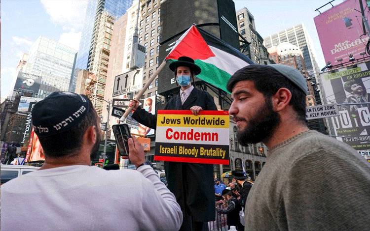Ultra Ortodoks Yahudi pro Palestina melakukan kontraprotes saat aksi unjuk rasa pro Israel di Times Square di New York City, Amerika Serikat, Rabu (12/5/2021). (foto : ANTARA FOTO/REUTERS/David 'Dee' Delgado/hp/cfo)