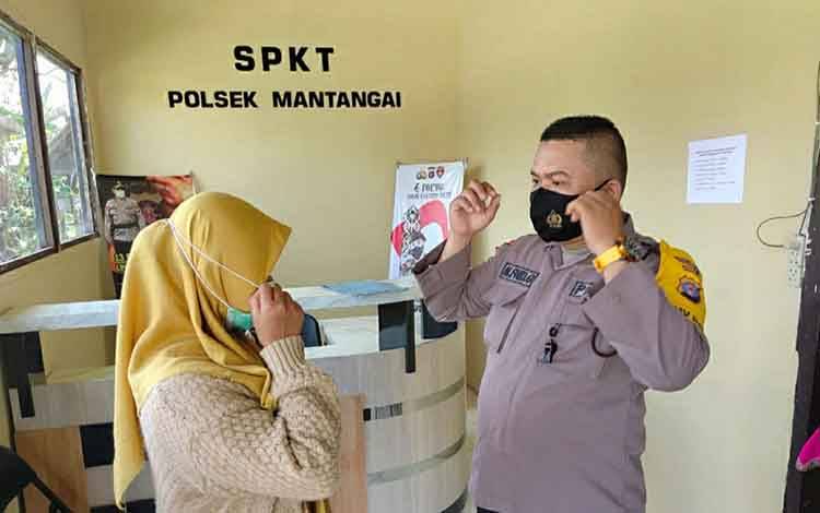 Personel Polsek Mantangai saat mengimbau warga untuk menggunakan masker di Mako Polsek setempat.