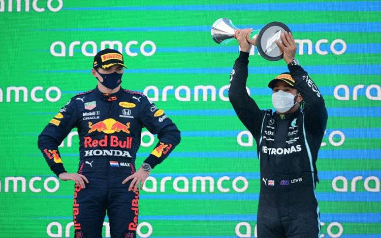 Pebalap tim Mercedes Lewis Hamilton (kanan) melakukan selebrasi di podium di samping pebalap Red Bull Max Verstappen (kiri) di Grand Prix Spanyol, Sirkuit Barcelona-Catalunya. (9/5/2021) (ANTARA/AFP/Lluis Gene)
