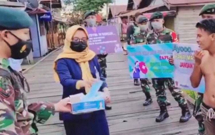 TNI-Polri serta pegawai Bank Mandiri saat membagikan masker gratis kepada masyarakat Flamboyan bawah.