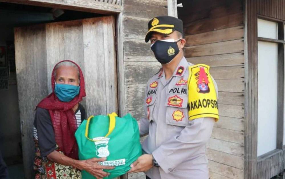 Wakapolres Kapuas, Kompol Iqbal Sengaji saat menyalurkan bantuan paket sembako untuk warga.